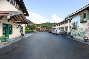 A street with parked cars, a building labeled 'OFFICE' on the left, and a mural on the right.