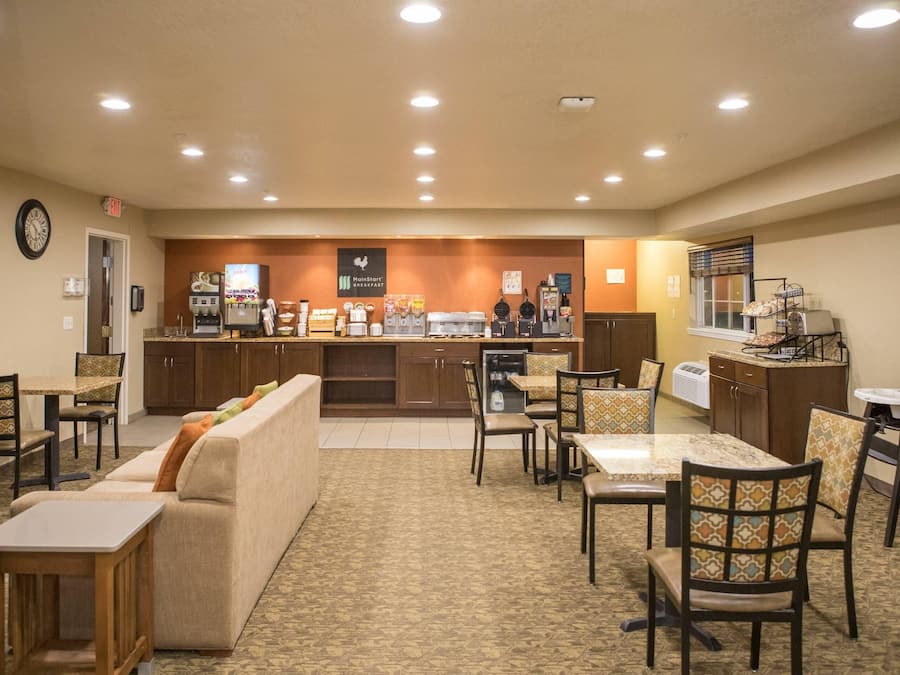 A hotel lobby with a reception desk, seating area, and a coffee station.