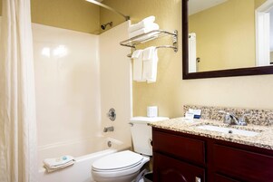 Un baño con ducha, inodoro, lavabo y toallero.
