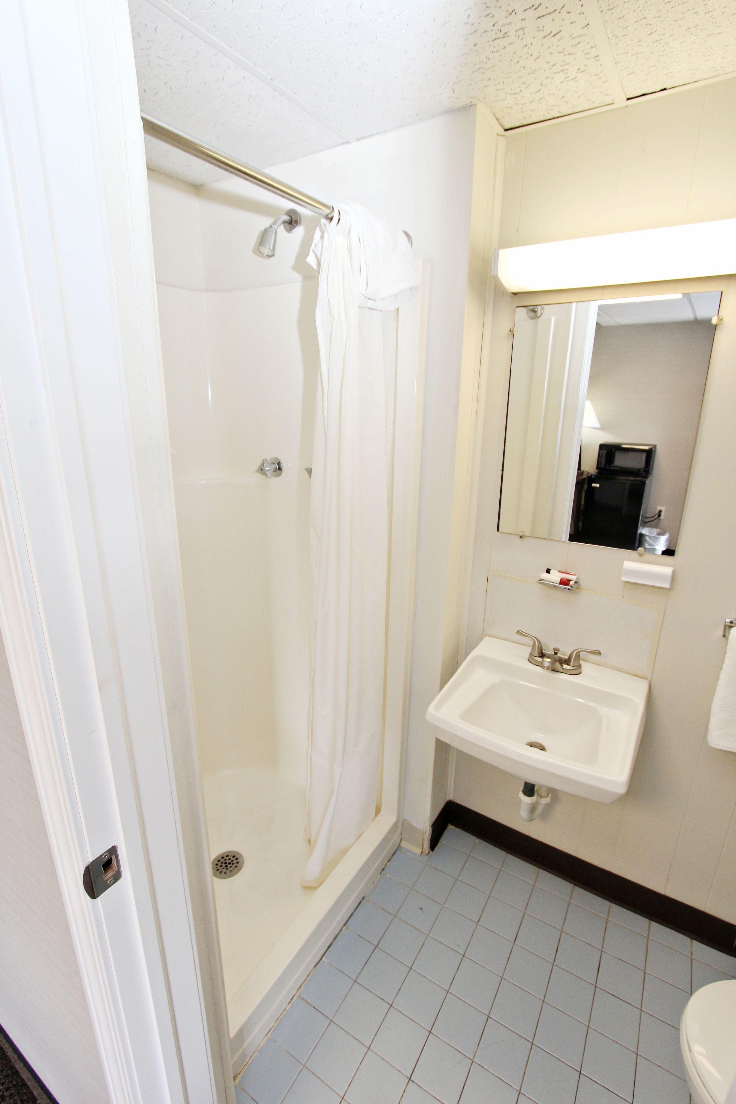 A bathroom with a shower, sink, and toilet.