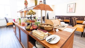A buffet setup with various food items and a coffee machine. - PrivatHotel Probst (Nuremberg)