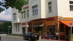 A multi-story building with a storefront on the ground floor. - Pension Messe am Funkturm (Berlin)