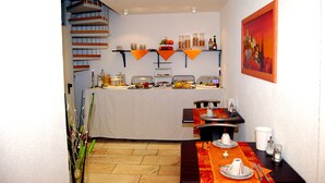 A dining area with a buffet setup, a staircase, and a painting on the wall. - Hotel Rheinischer Hof (Düsseldorf)