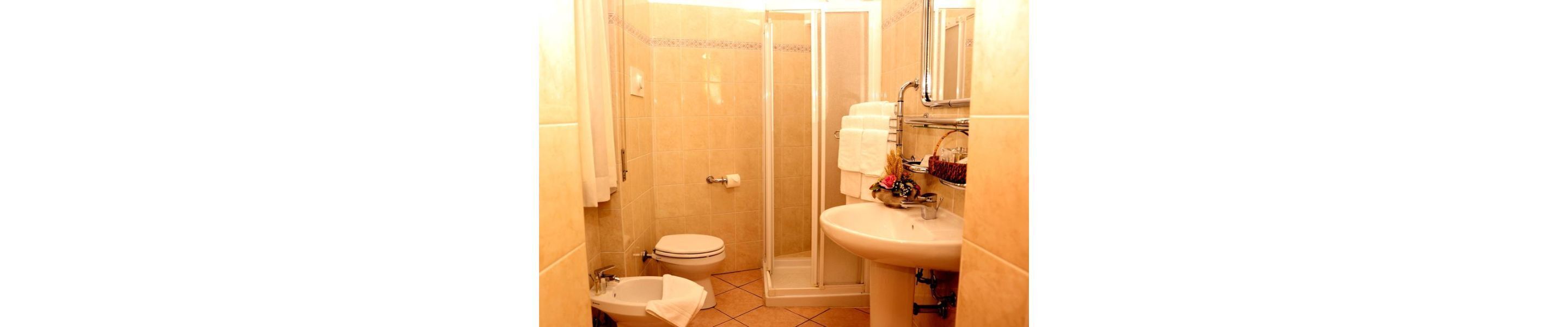 A compact bathroom with a toilet, sink, and shower.