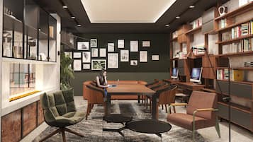 A modern library with a central table, bookshelves, and artwork on the walls.