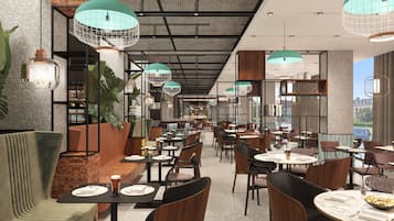 Interior de restaurante con varias áreas de estar, incluyendo cabinas y mesas, y lámparas colgantes.