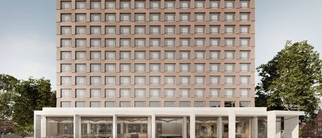 A modern hotel with a grid of windows and a covered entrance.