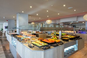 A buffet with various food items and a modern interior design.