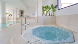 A hot tub area with a pool, a lifebuoy, and potted plants. - Marins Playa (Son Servera)