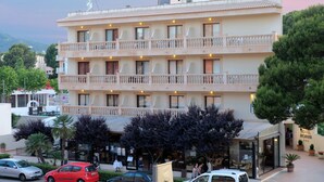 A multi-story hotel with balconies, a restaurant, and a parking area. - Hotel Bell Port (Capdepera)