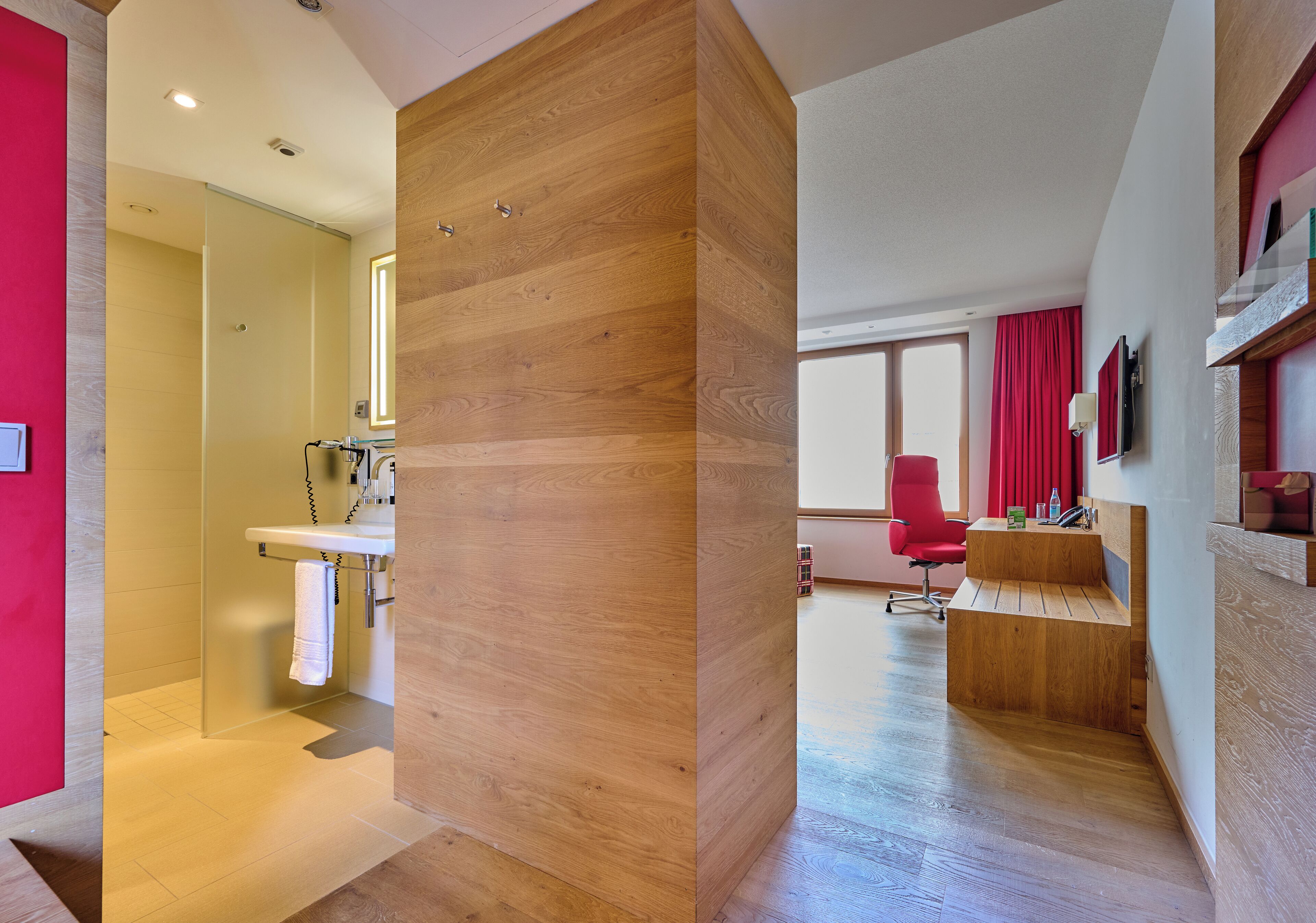 A modern bathroom with a glass shower enclosure and a wooden vanity.
