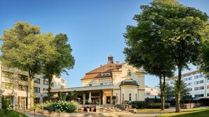 Un hotel con un patio central, una zona de estar al aire libre cubierta y un edificio clásico con cúpula.