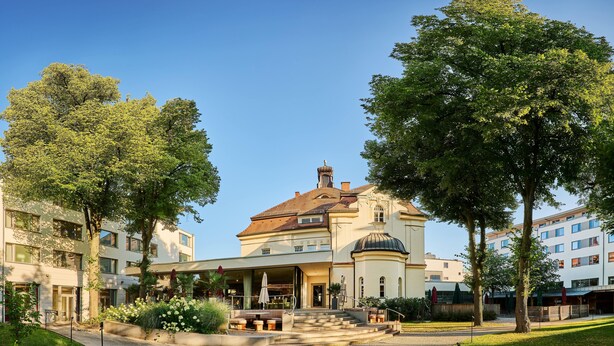 A hotel with a central courtyard, a covered outdoor seating area, and a classical building with a dome.
