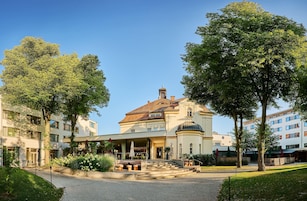 Un hotel con un patio central, una zona de estar al aire libre cubierta y un edificio clásico con cúpula.