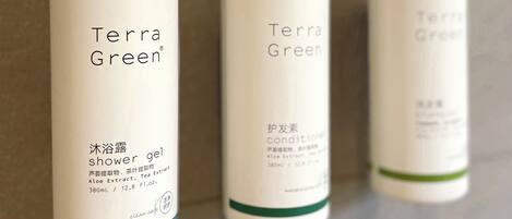 Three bottles of Terra Green products on a tiled wall.