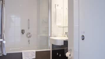 A modern bathroom with a bathtub, shower, toilet, and sink.