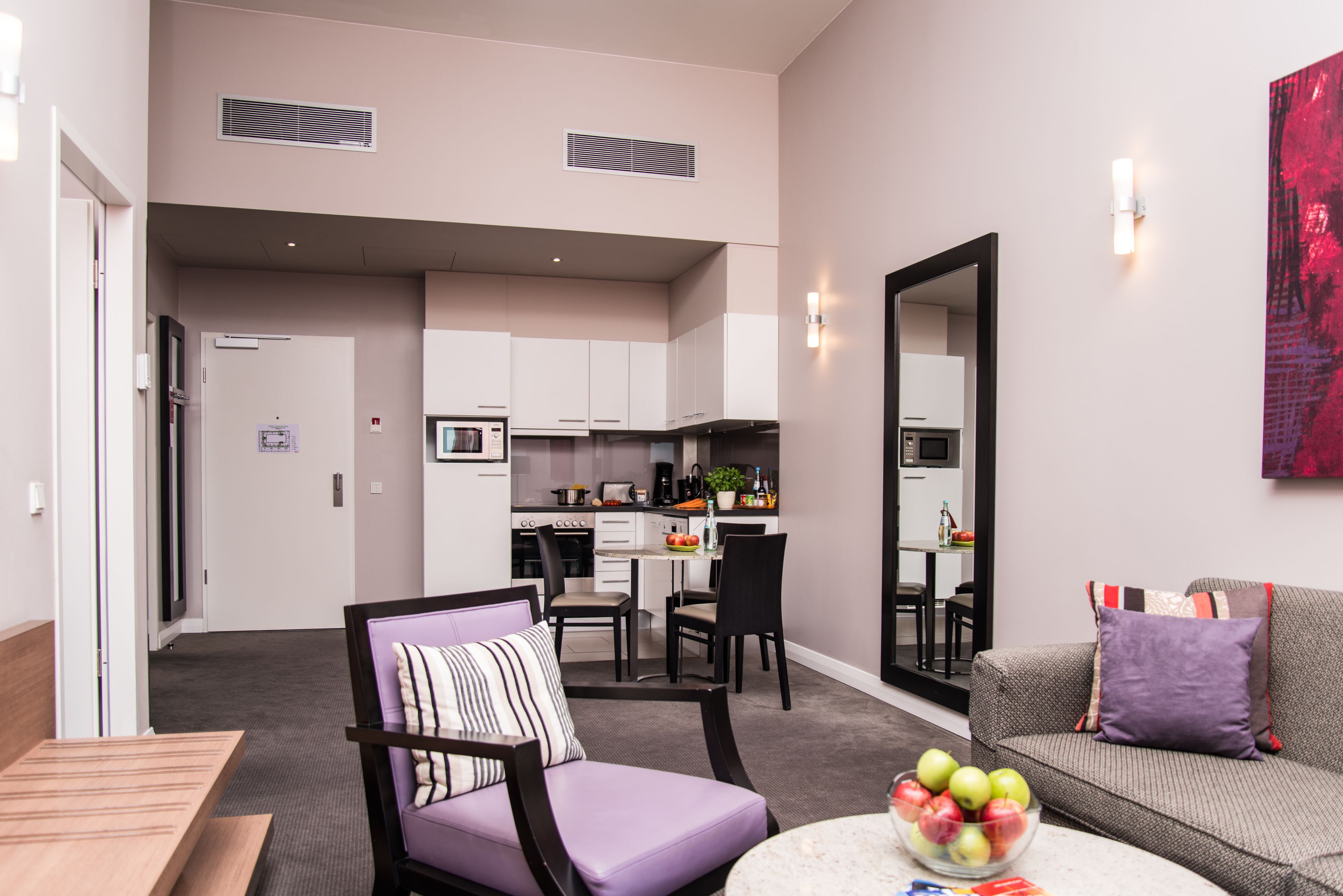 Un appartement moderne comprenant un coin repas, une kitchenette et un salon avec un canapé et une table basse.