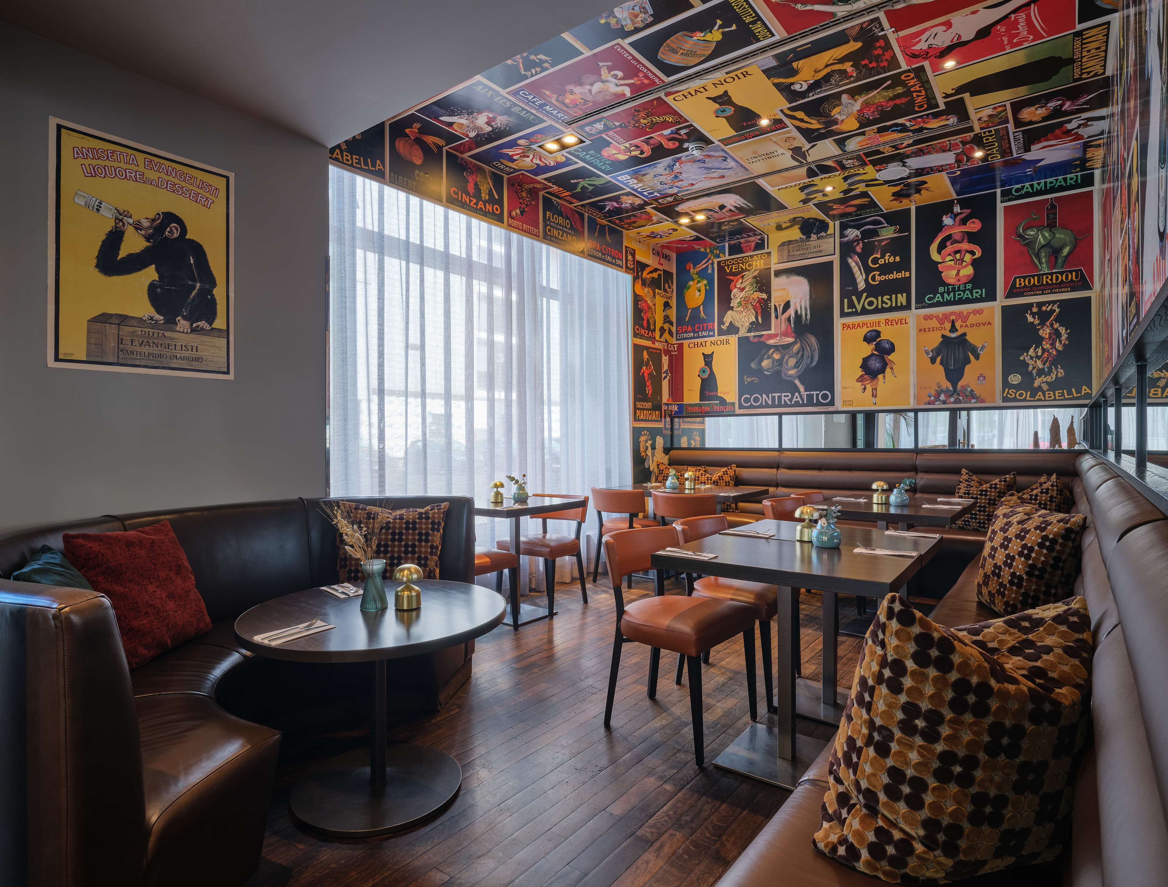 A cozy restaurant interior with a vintage-themed ceiling, wooden floors, and comfortable seating.