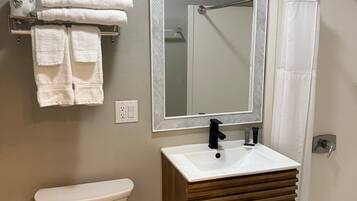 Un baño con inodoro, lavamanos y ducha.