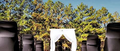 A tent set up in a grassy area with trees in the background.