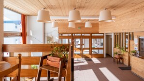 A wooden interior with a reception desk, potted plants, and a bench. - Résidence Pierre & Vacances Val Thorens Le Gypaete (Les Belleville)
