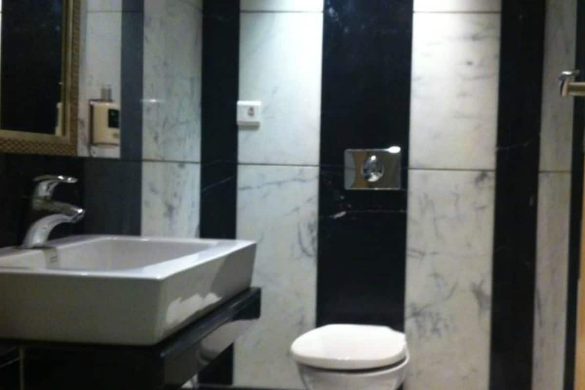 A bathroom with a sink, toilet, and a mirror.