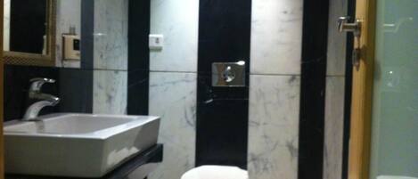 Une salle de bain avec un lavabo, des toilettes et un miroir.