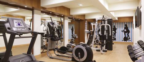 A gym with treadmills, elliptical machines, and free weights.