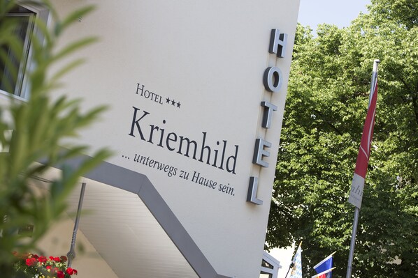 A sign for Hotel Krimhild with a modern design and a staircase leading to the entrance.