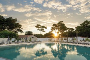 Een buitenzwembad, ligstoelen bij het zwembad