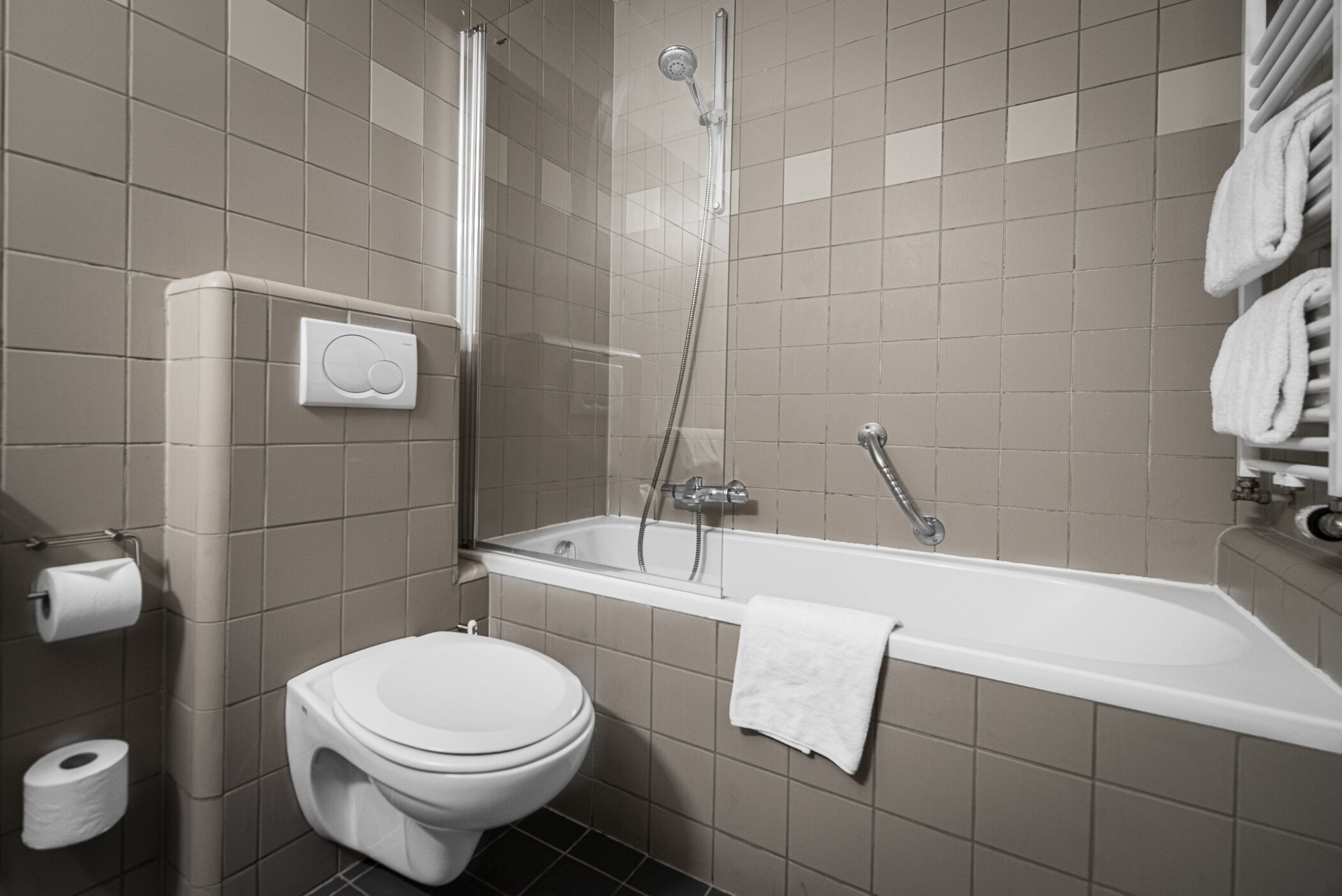 A modern bathroom with a toilet, a shower, and a bathtub.