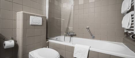 A modern bathroom with a toilet, a shower, and a bathtub.