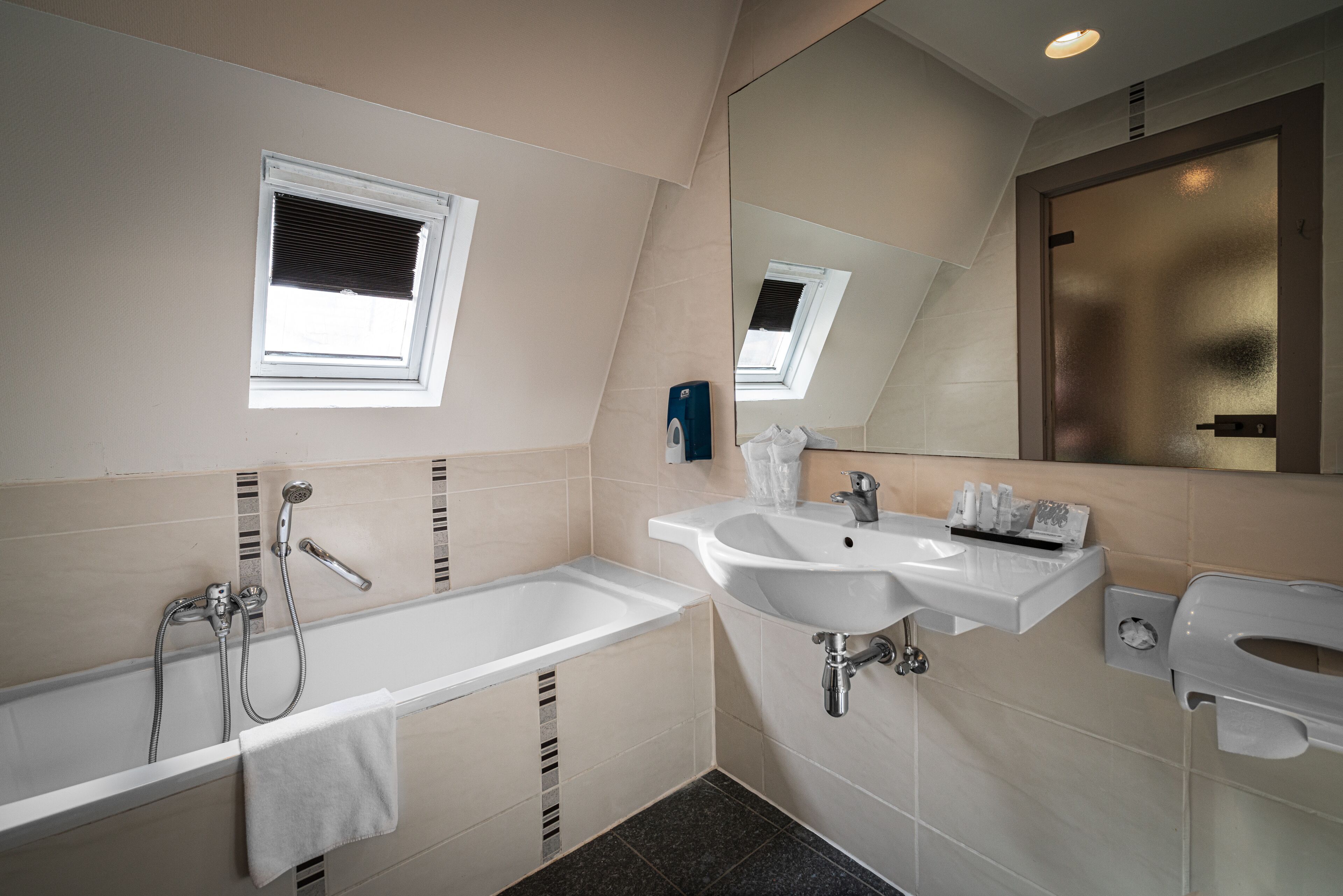 Een moderne badkamer met een badkuip, wastafel en spiegel.