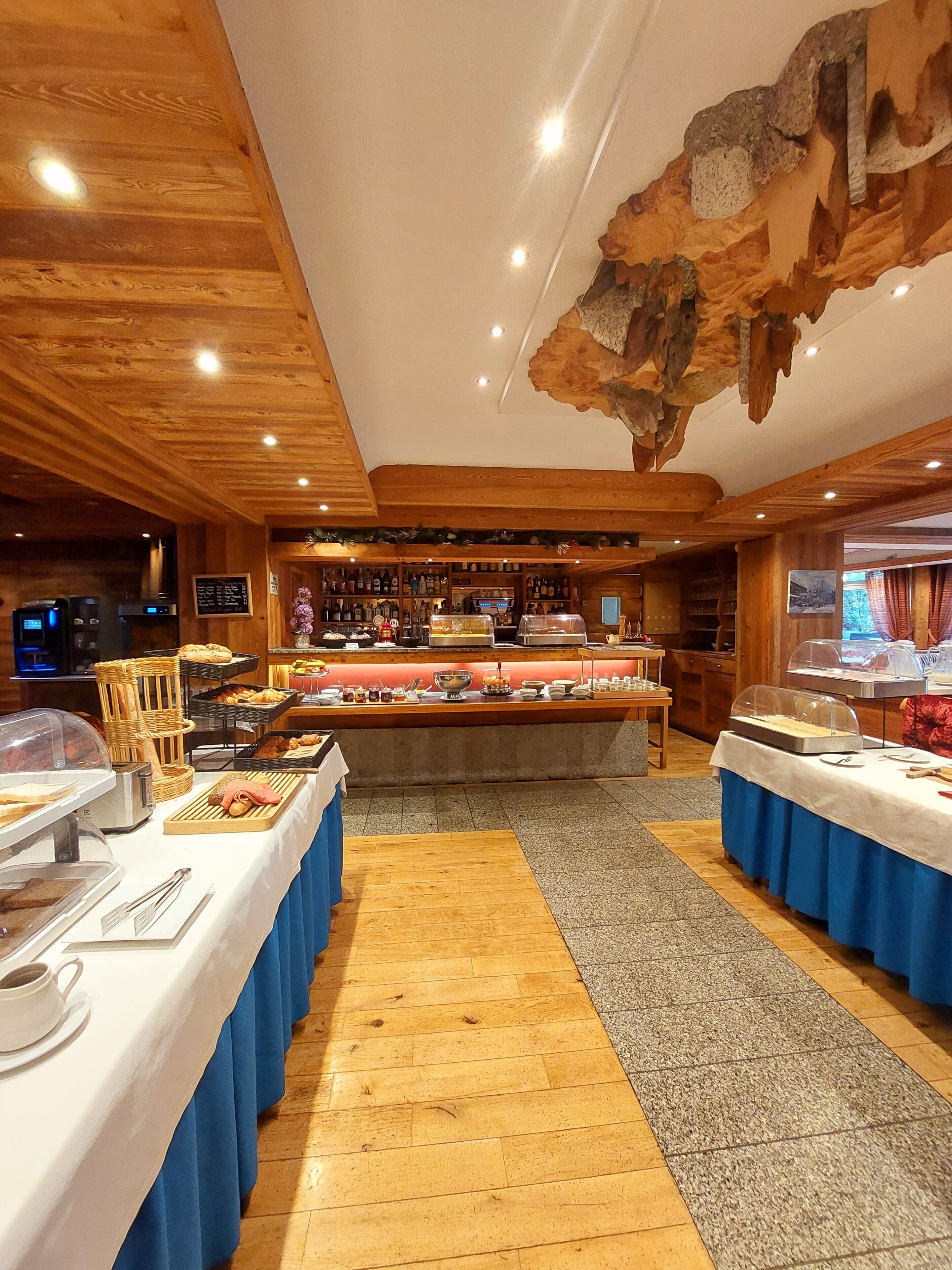 A buffet area with a wooden ceiling and a stone wall.