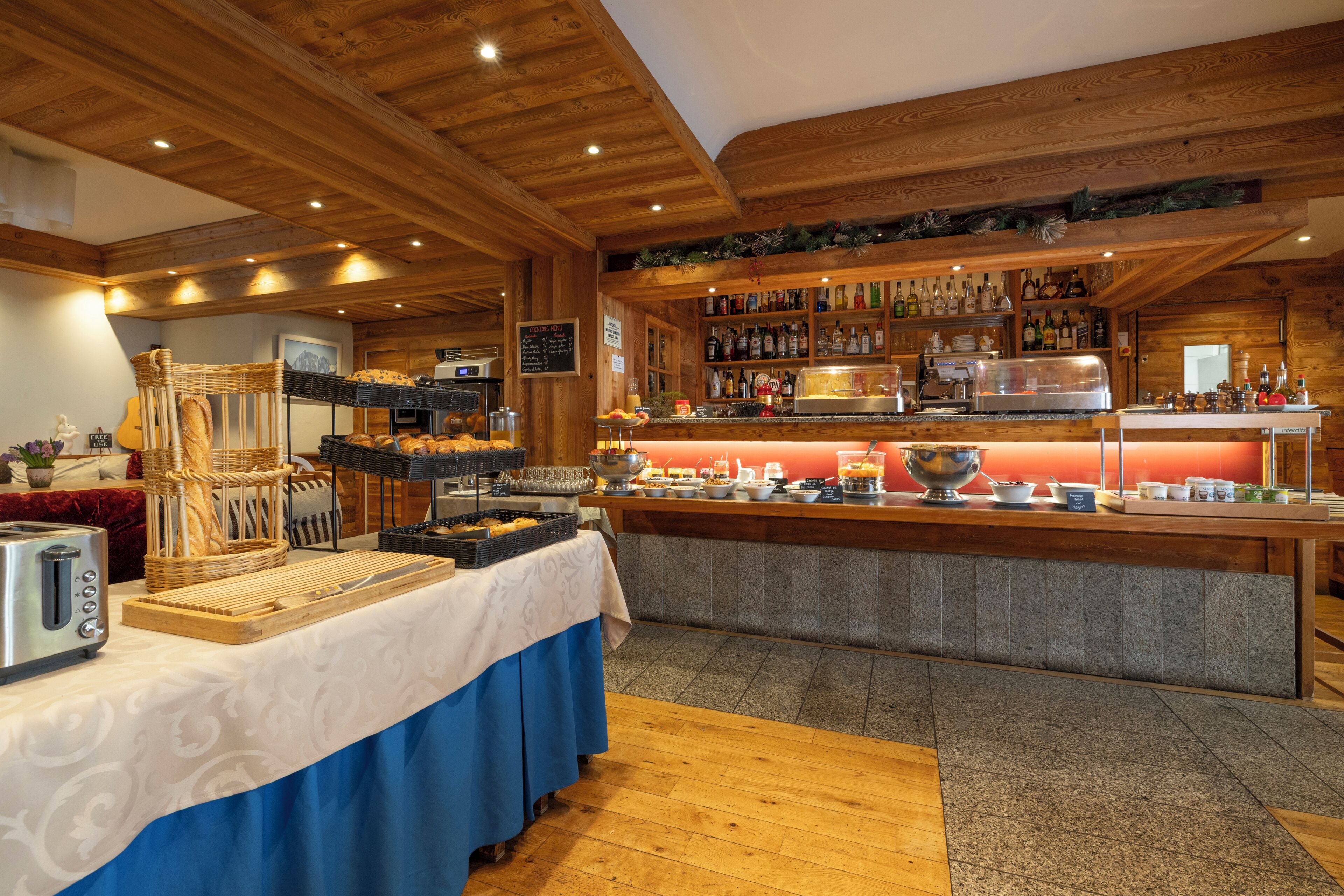 A buffet setup with bread baskets, a toaster, and a variety of beverages.