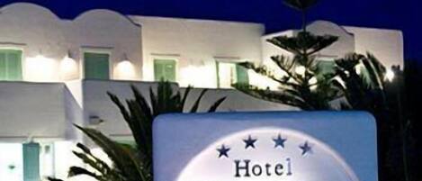 A sign for Hotel Daedalus with a modern white facade and green windows.