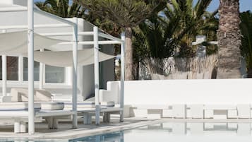 Een buitenzwembad, parasols bij het zwembad en ligstoelen