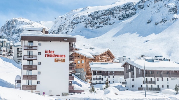 A snow-covered mountain resort with a building labeled "inter résidences maeva" and another building with "ucpa" signage.