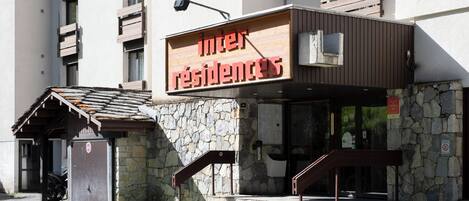 Ein Gebäude mit einem Schild, auf dem 'inter residences' steht, und einer Steinfassade.
