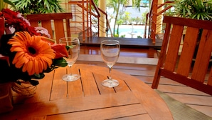 A wooden table with two wine glasses and a vase of flowers. - La Pointe Villas (Grand-Baie)