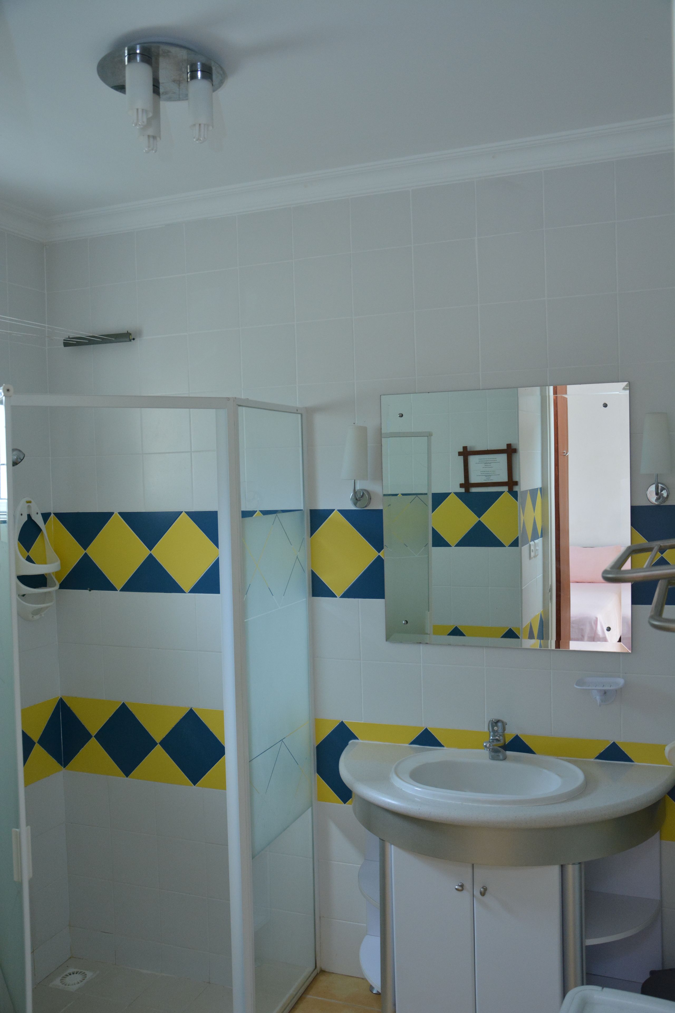 A bathroom with a shower, sink, and mirror.