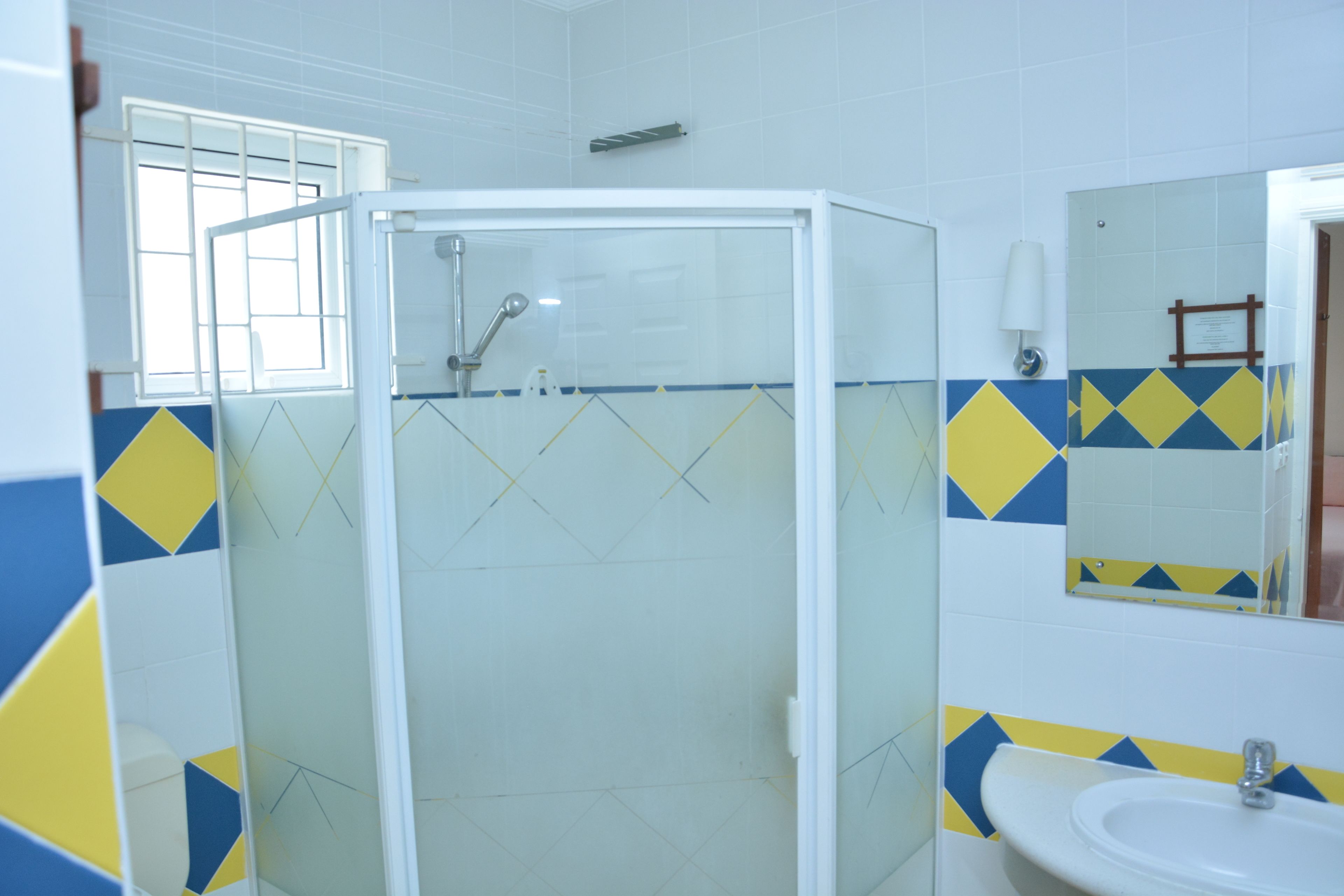 A bathroom with a shower enclosure, a sink, and a mirror.