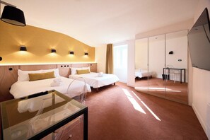 Una habitación de hotel con dos camas, una mesita de cristal, un espejo y un ventanal grande.