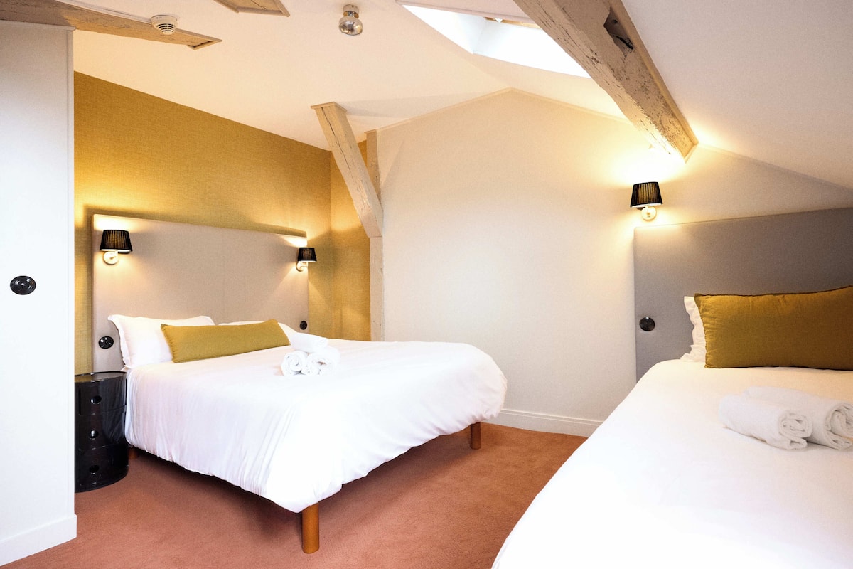 Un dormitorio con dos camas, una mesita de noche, una lámpara y un ventilador de techo.