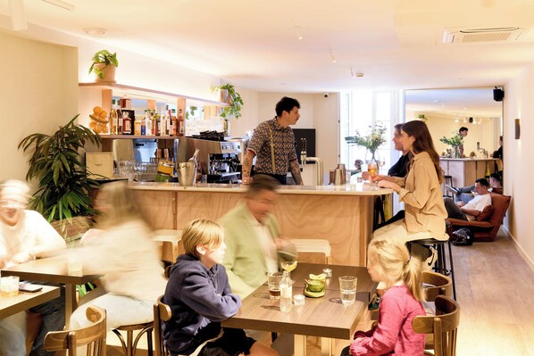 A restaurant with a bar area, wooden furniture, and a casual dining atmosphere.