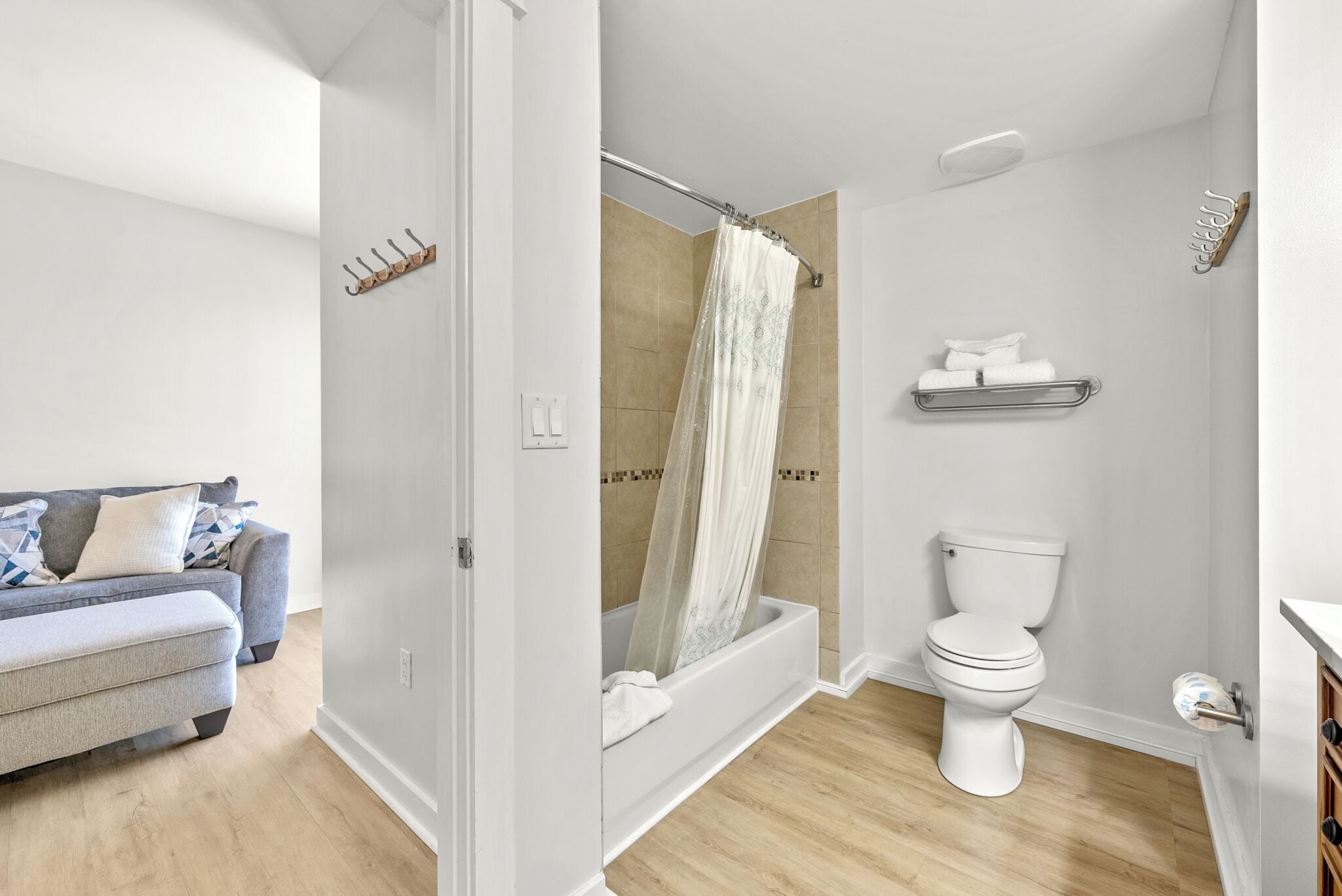 A modern bathroom with a shower, toilet, and a towel rack.