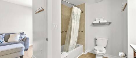 A modern bathroom with a shower, toilet, and a towel rack.