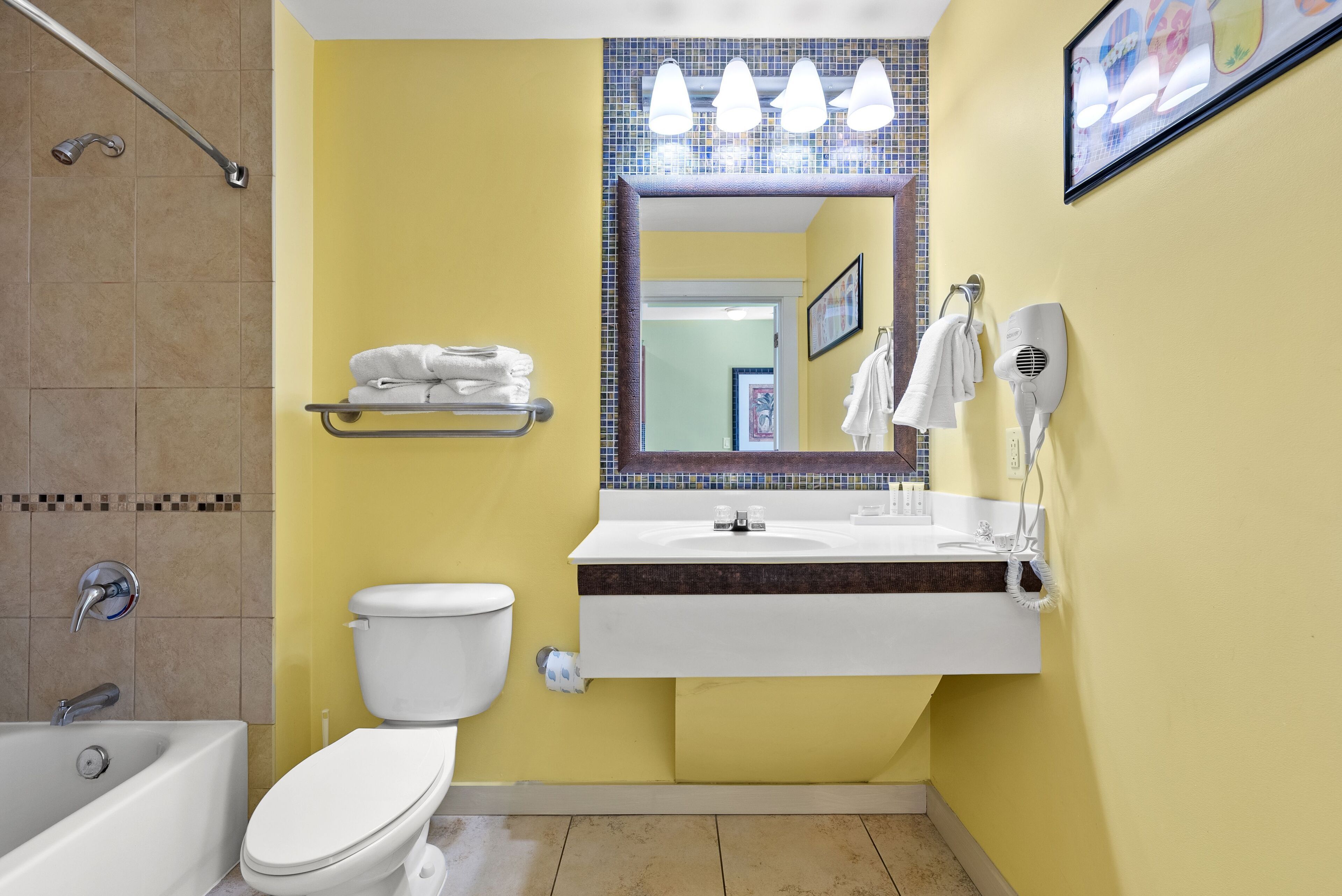 A bathroom with a bathtub, toilet, and sink.