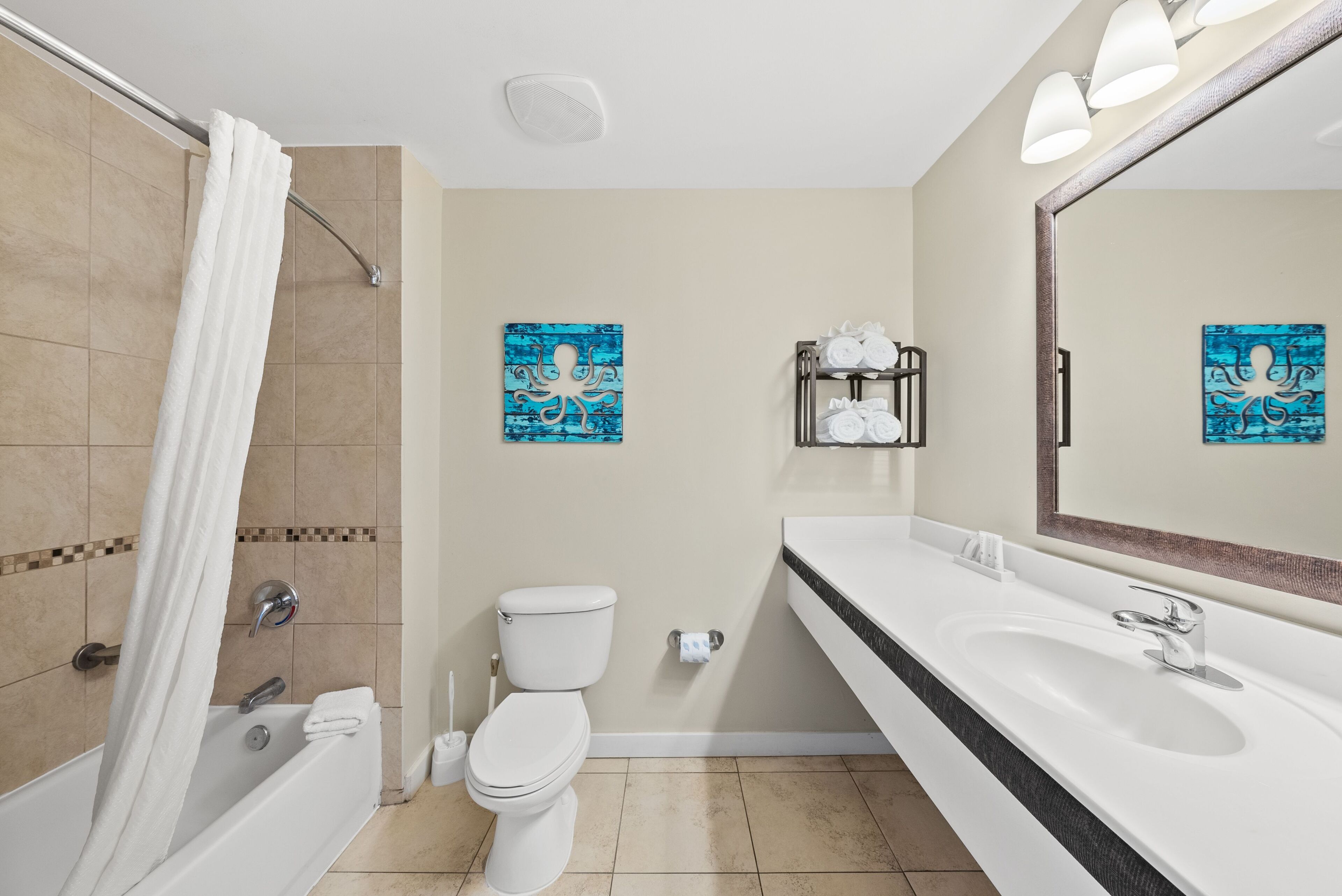 Ein Badezimmer mit Badewanne, Toilette, Waschbecken und Handtuchhalter.