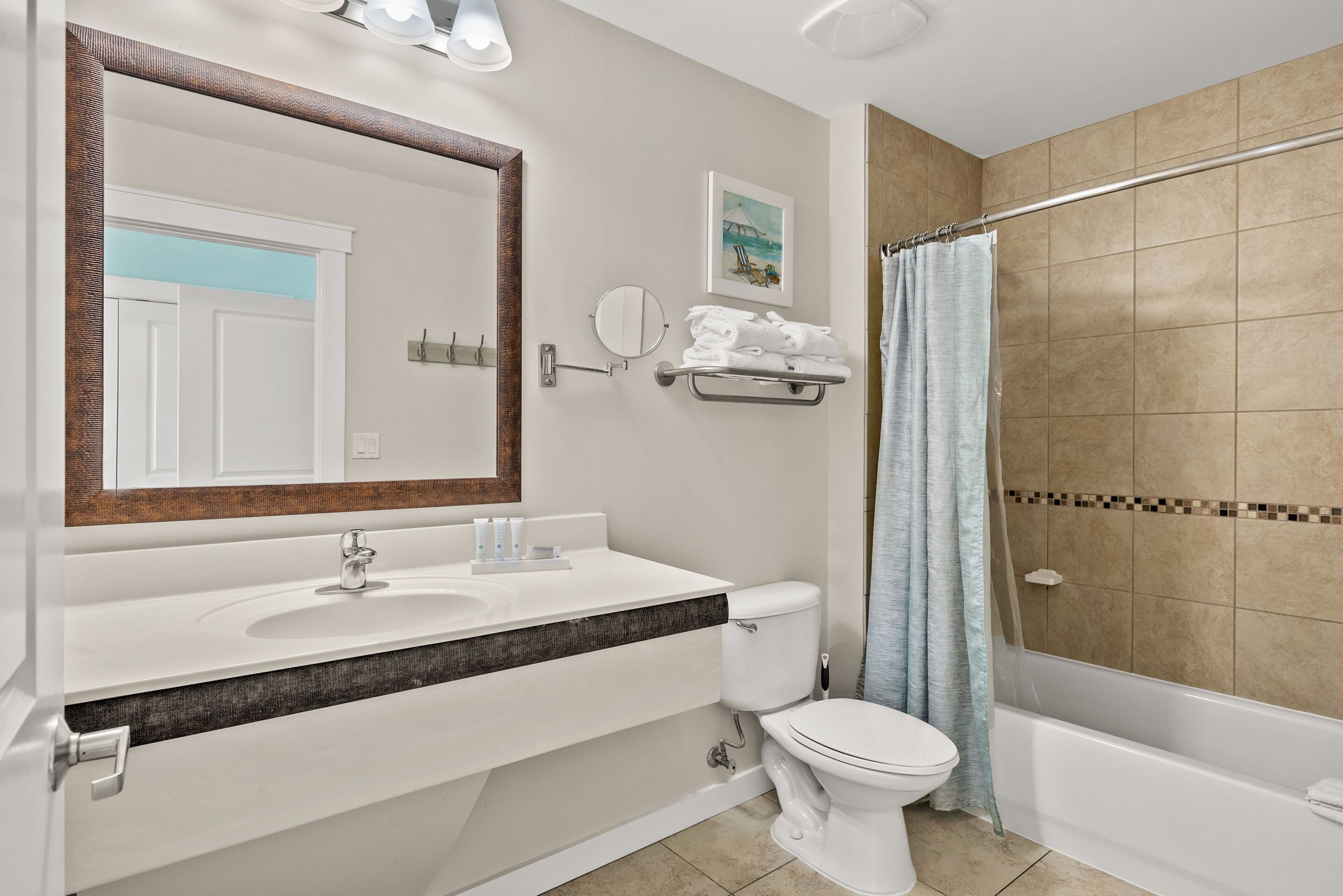 A bathroom with a white sink, a toilet, a bathtub, and a shower curtain.